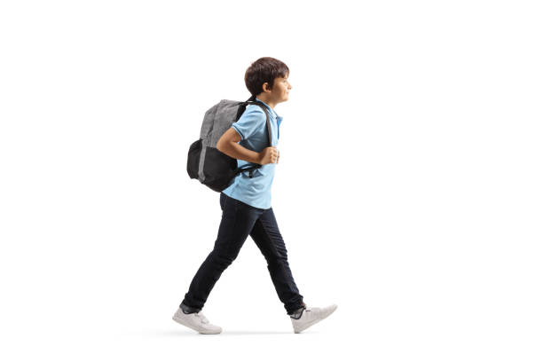 Schoolboy with a backpack walking Full length profile shot of a schoolboy with a backpack walking isolated on white background one boy only photos stock pictures, royalty-free photos & images