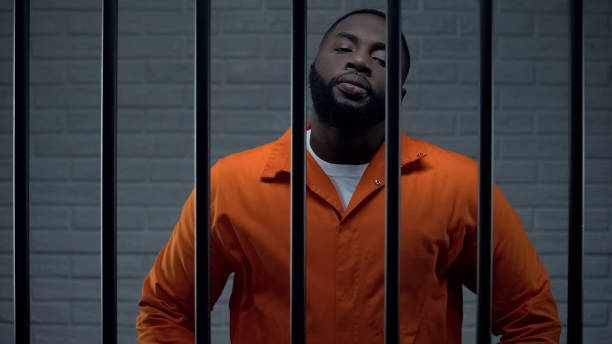 istock Impudent black prisoner in cell looking directly to camera, dangerous criminal 1167839935