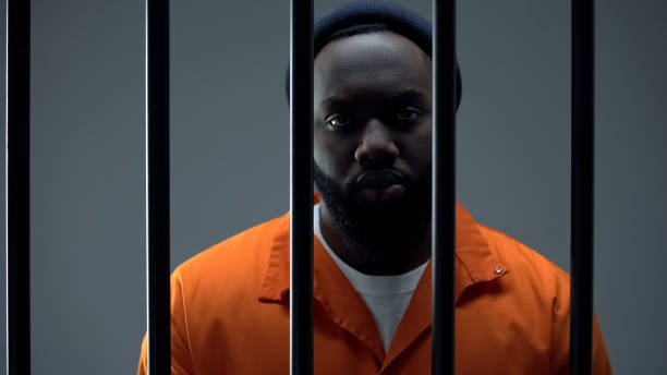 istock Evil prisoner looking at camera through bars feeling regret for committing crime 1167839946