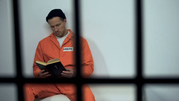 istock Caucasian prisoner reading bible in cell, convicted sinner turning to religion 1167839989