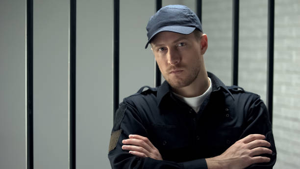 istock Confident prison security guard looking to camera standing near cell, profession 1167840139