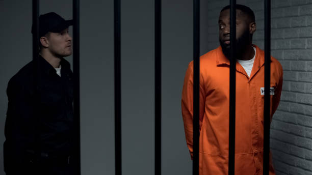 istock Security guard convoying afro american criminal, prison rules and regulations 1167840171