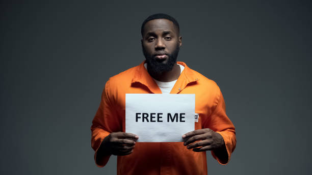 African-american prisoner holding free me sign in cell, innocent asking for help African-american prisoner holding free me sign in cell, innocent asking for help arrest photos stock pictures, royalty-free photos & images