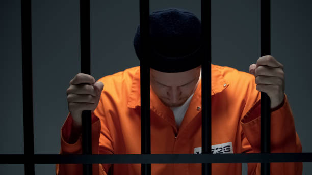 istock Prisoner holding bars and leaning head, feeling depressed, psychological rehab 1167840413