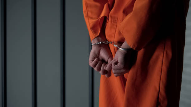 Prisoner with handcuffed arms behind back, another jail transfer, criminal Prisoner with handcuffed arms behind back, another jail transfer, criminal killercell stock pictures, royalty-free photos & images