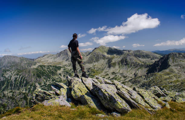 Retezat Mountains/Romania-August 14, 2016: Man admiring the rocky mountain landscape.