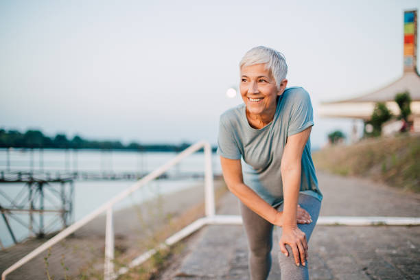Senior woman exercising by the river stock photo