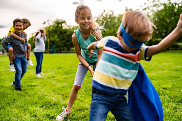 the little superhero is playing with friends - partnership creativity superhero child imagens e fotografias de stock