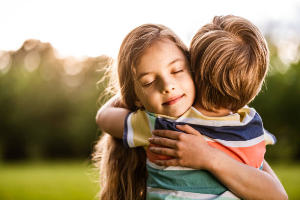 Sister hugs her little brother