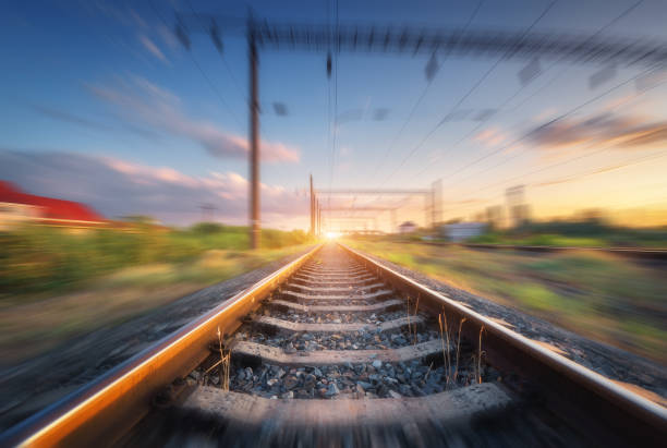 istock Railroad and beautiful blue sky with clouds at sunset with motion blur effect in summer. Industrial landscape with railway station and blurred background.  Railway platform in speed motion. Concept 1167856657