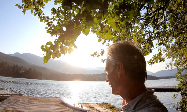 istock Mature man on dock over a mountain lake in the morning 1167857793