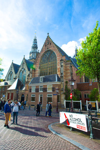 Amsterdam, Holland: Tourists and a “No Alcohol in Public Spaces” sign near the Oude Kerk (Old Church) in the Red Light District in downtown Amsterdam.