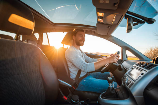 istock Young man driving car on a sunny day 1167863810