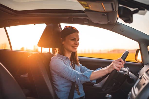 istock Young woman driving car on a sunny day 1167863814