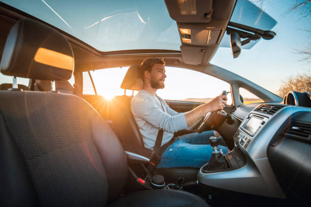 istock Young man driving car on a sunny day 1167863884