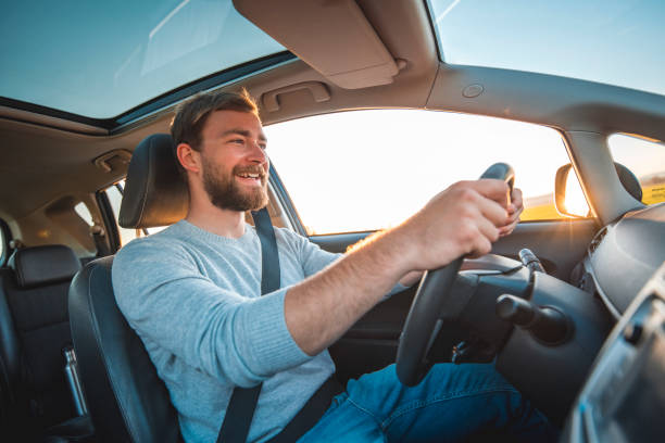 Young man driving car on a sunny day