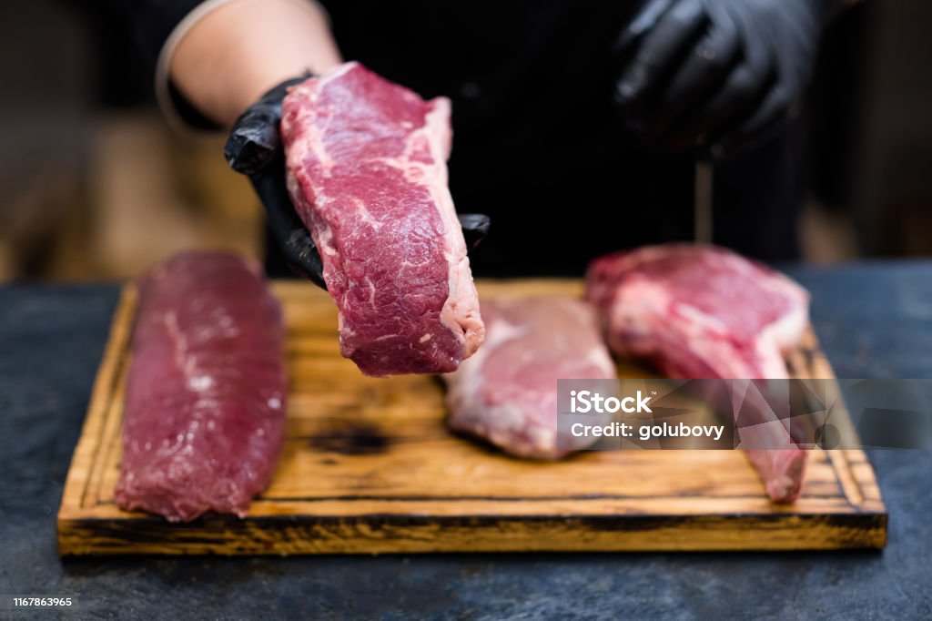 butcher shop fresh cuts raw beef meat chef steaks Butcher shop. Fresh cuts, raw beef meat assortment on wooden board. Chef cooking steaks. Meat Stock Photo