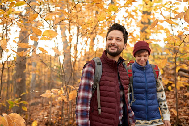 Attractive caucasian couple hiking through the forest in the fall in Canada stock photo