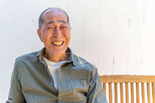 istock Happy Senior Asian Man Sitting in his Backyard 1167873978