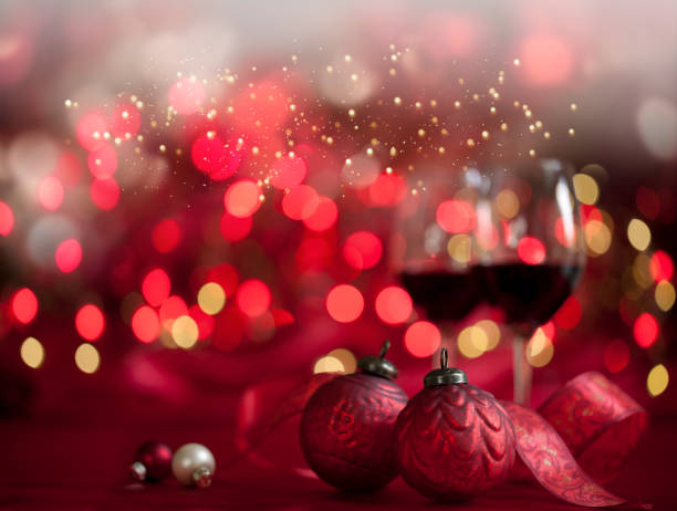 Christmas wine amd baubles against a defocused lights background
