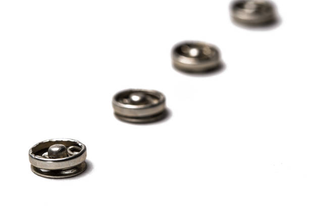 Isolated photo of various colored plastic decorative cloth buttons or rivets on white background.