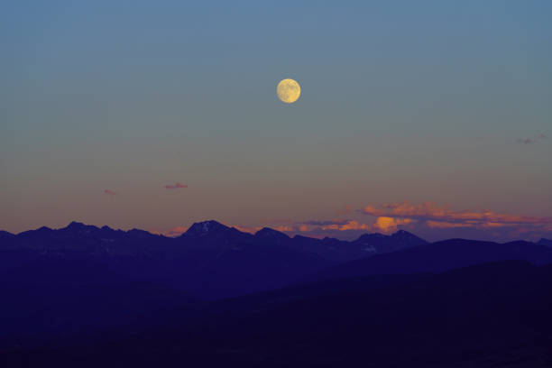 Caucasus, Georgia, Tusheti region, Omalo. The moon rises over a mountain lit by the setting sun in the Tusheti region.