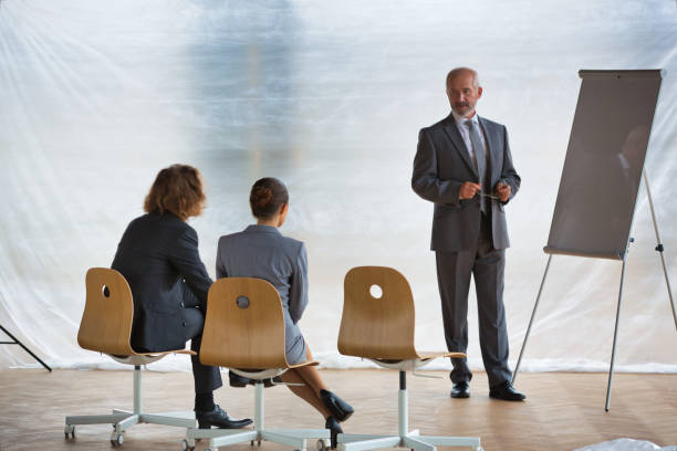 istock Senior businessman explaining strategy to colleagues on whiteboard at office 1167894179
