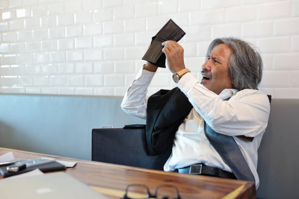 istock senior businessman wearing black suit viewing empty wallet because of failure from doing business 1167894851
