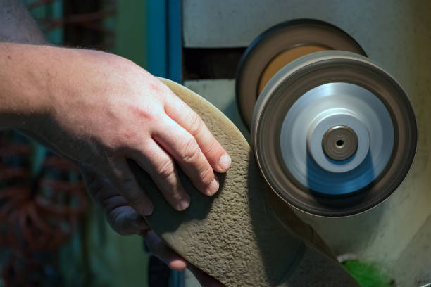 istock Male shoemaker hands grinding and shaping a sole in his workshop, close up. 1167896835