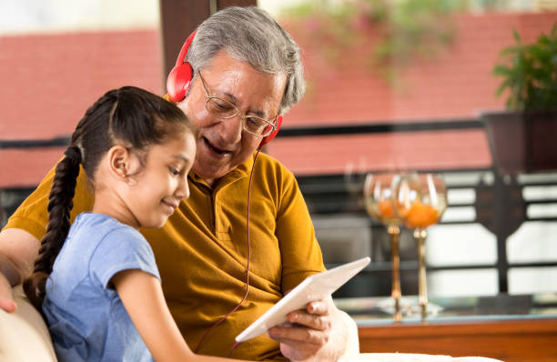 istock Grandfather with granddaughter using digital tablet and headphones 1167900367