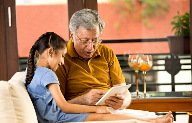 istock Grandfather with granddaughter using digital tablet 1167901662