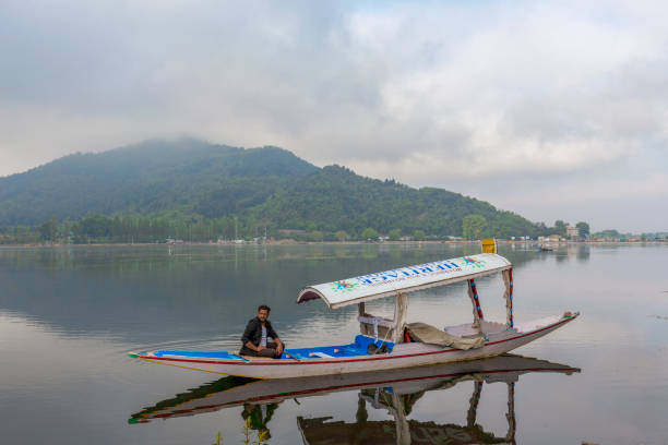 shikhara or Shikara boat floating on dal lake early morning unidentified boatman is sailing with his boat and looking for tourists in  Dal Lake, Sri Nagar, Jammu & Kashmir, India on june 23, 2018 lake nagin stock pictures, royalty-free photos & images