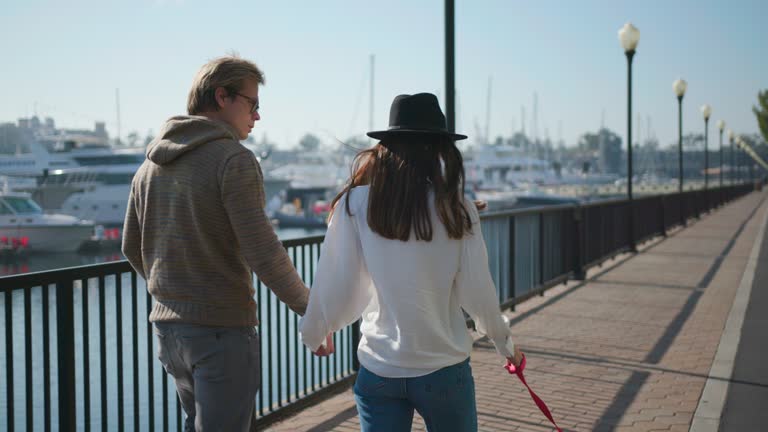 Young couple have a walk by the seaside with dog