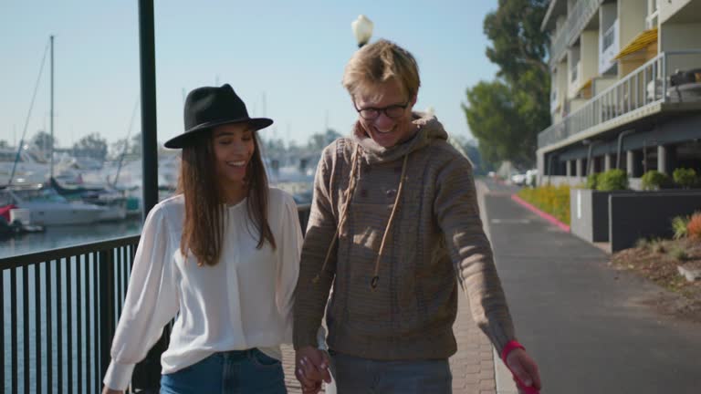 Young couple have a walk by the seaside with dog