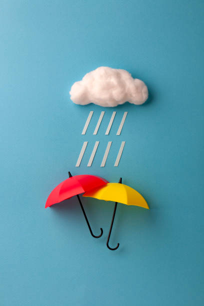 istock two umbrellas under the cloud on sky blue background 1167905717