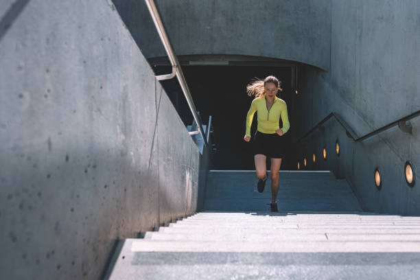 young sports woman running up stairs young sports woman running up stairs from subway sation muster station stock pictures, royalty-free photos & images