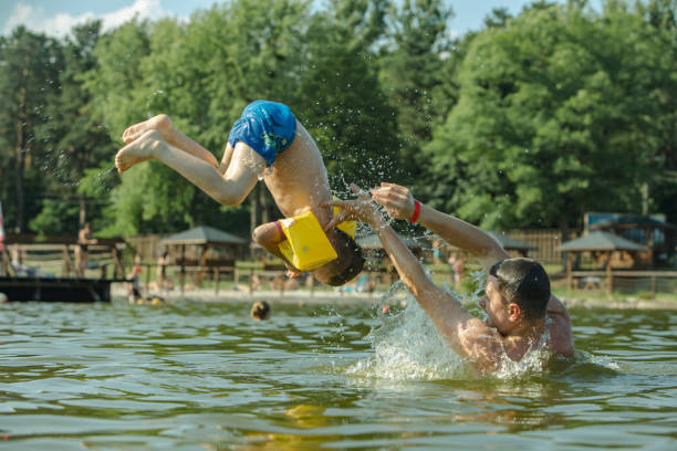istock father throwing son in water having fun 1167908886