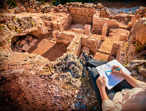 archaeologist taking notes at roman ruins