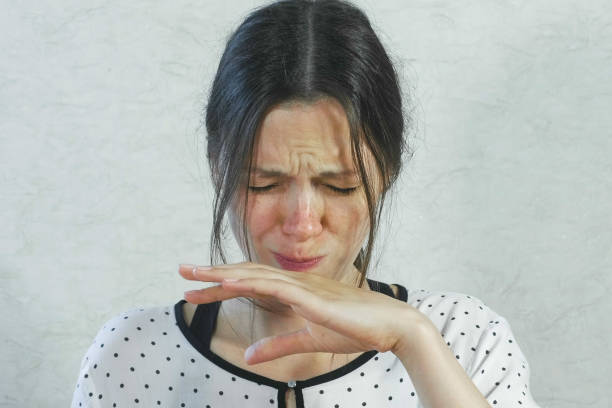 Emotions from the sour on the girl's face. Brunette woman eating sour tangerine and wincing. Emotions from the acid on the girl's face. Brunette woman eating sour tangerine and wincing sour taste stock pictures, royalty-free photos & images