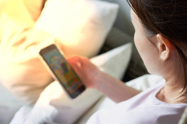 istock Woman texting or playing on smartphone on sofa 1167916368