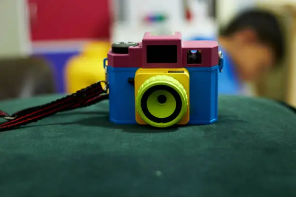 Photo of plastic Toy camera on fluffy chair