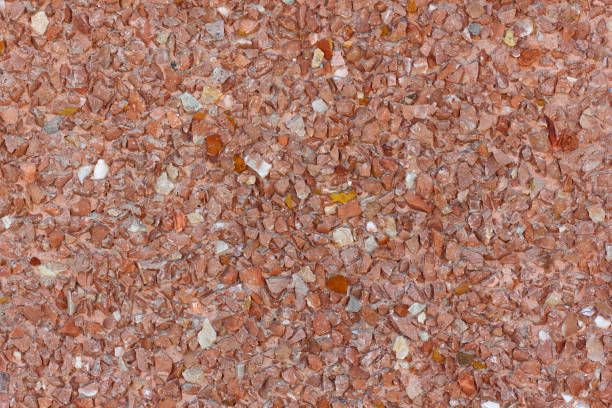 Background small red and orange stones on the plaster on the wall, uniform structure.