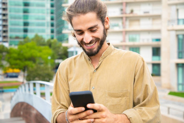 istock Happy excited hipster guy holding smartphone and smiling 1167919009