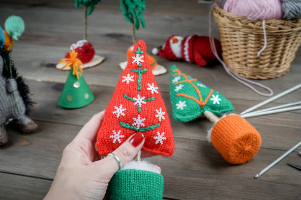 Knitted Christmas gifts handmade. Wooden background. Making knit New Year decoration. Christmas ornaments. stock photo