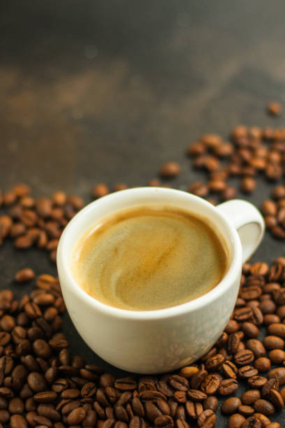 istock coffee drink in white cup and sprinkle coffee beans on the table. food background. top. copy space 1167921459