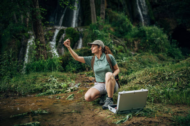 istock Woman biologist taking a water sample in nature 1167923045