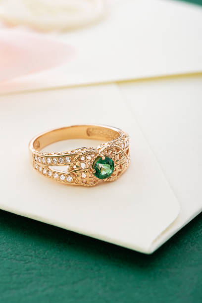 istock Wedding ring with emerald green gemstone on invitation envelope 1167923397