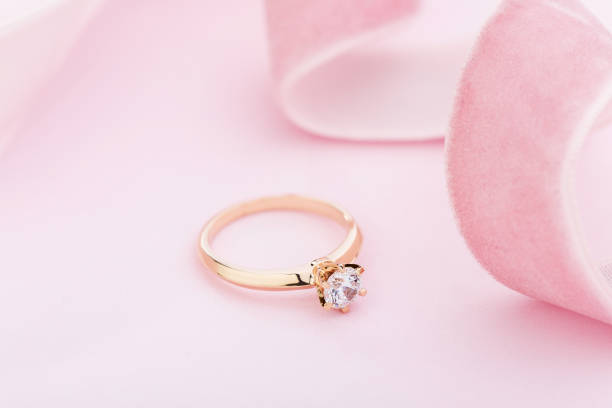 istock Wedding diamond ring on pastel background with pink ribbon 1167923413