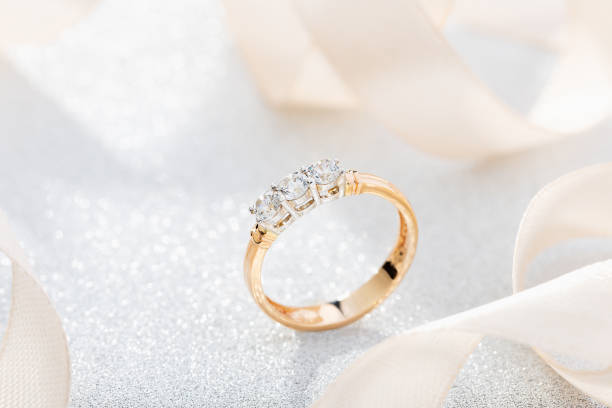 istock Wedding diamond ring on glossy background with beige ribbon 1167923416