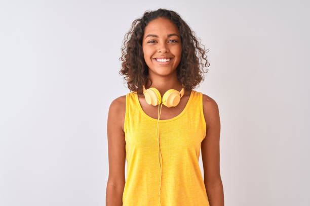 young brazilian woman wearing yellow headphones over isolated white background with a happy and cool smile on face. lucky person. - teenager teenagers only one teenage girl only human face imagens e fotografias de stock